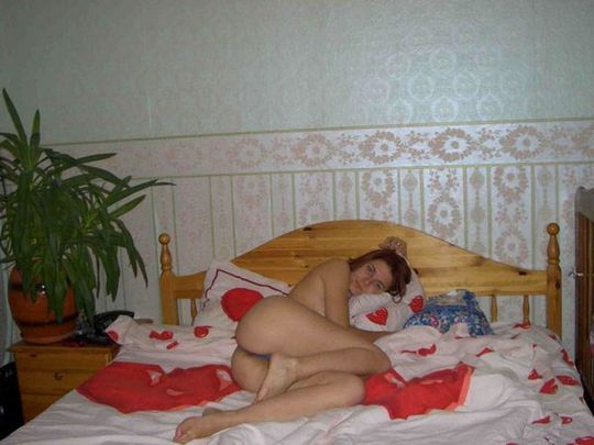 Молодая, русская женщина лежит голая на кровати